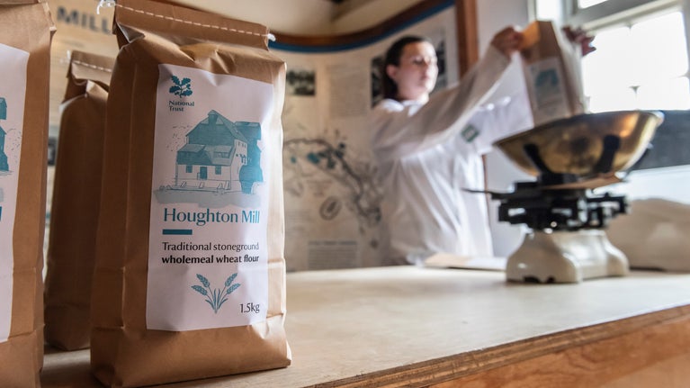 A lady filling bags of flour inside Houghton MIll